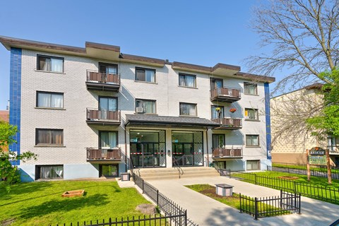 A modern apartment building with a black fence in front.