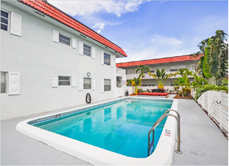 a swimming pool in the backyard of a white building