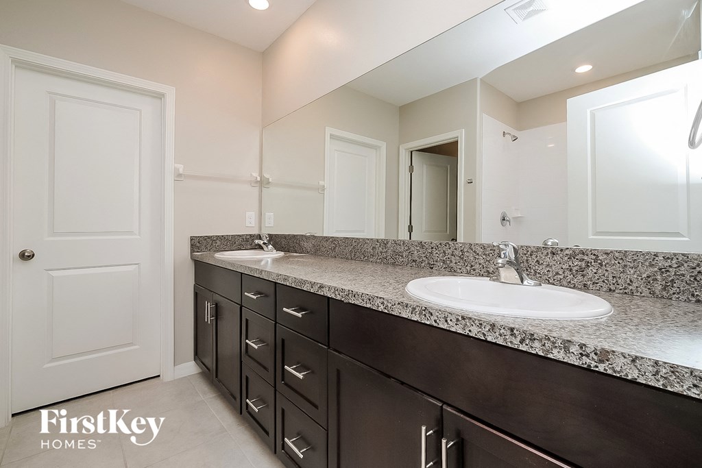 the master bathroom has a large vanity with a sink and a mirror