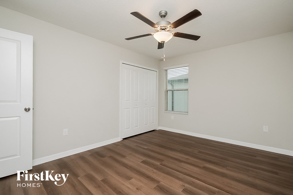 the living room of an empty house with a ceiling fan