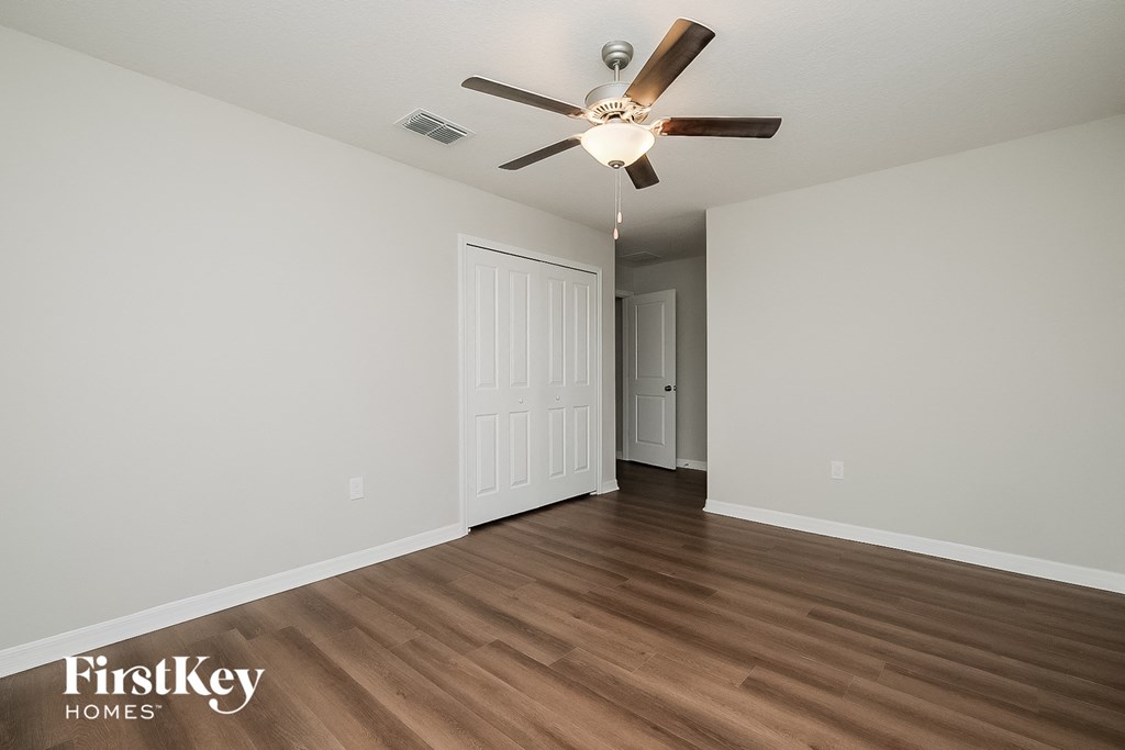 a living room with hardwood floors and a ceiling fan