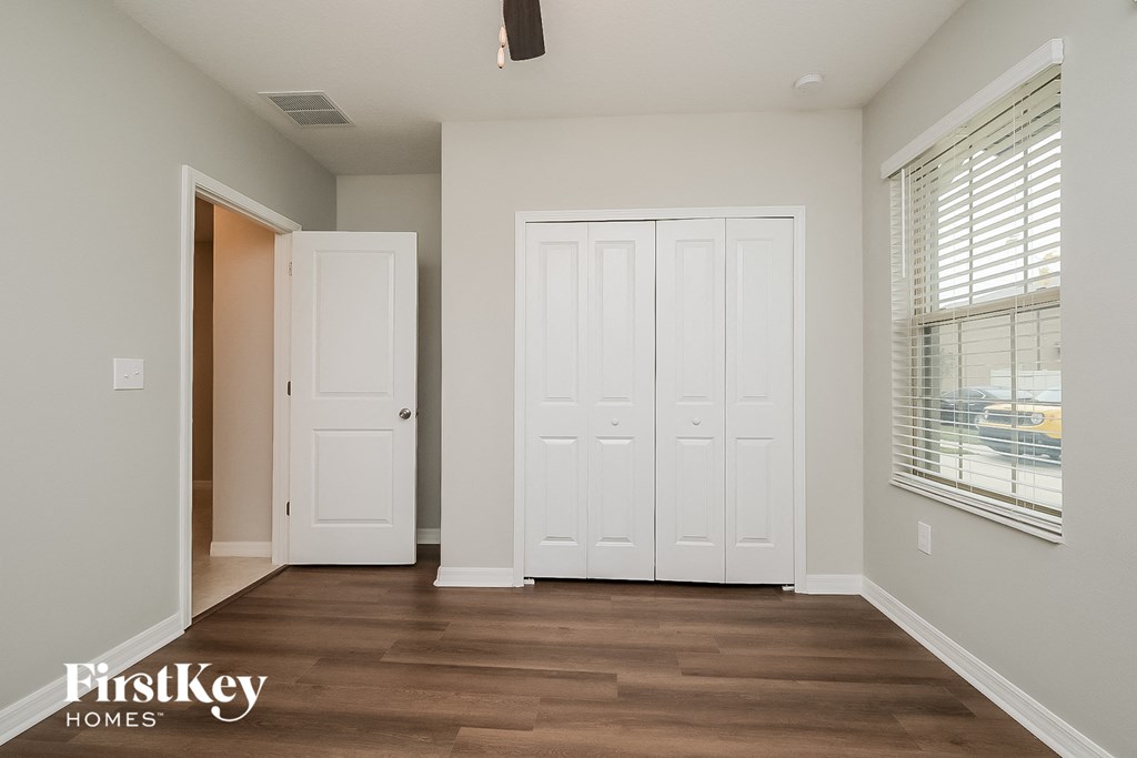 a bedroom with two closets and a door to a hallway