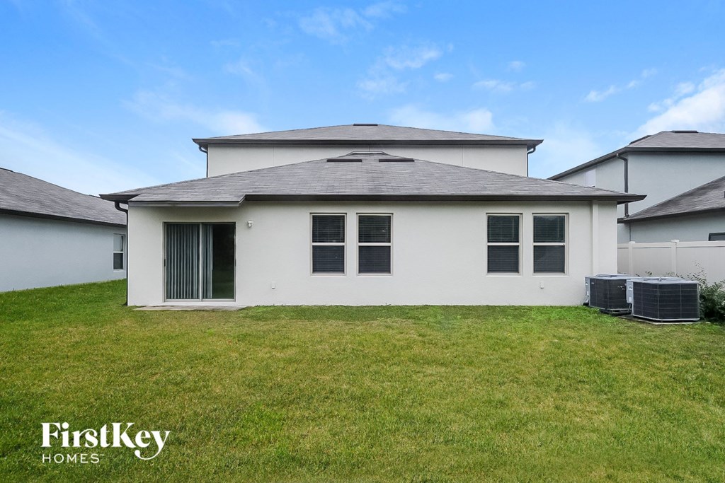a white house with a grass yard and a blue sky