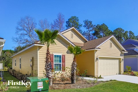 a yellow house with palm trees in front of it
