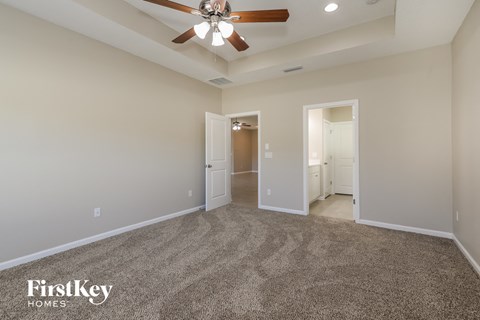 a spacious living room with carpet and a ceiling fan