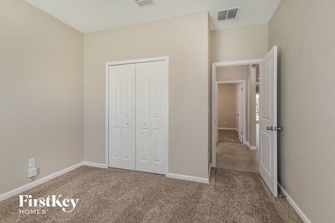 a bedroom with two closets and a door to a hallway