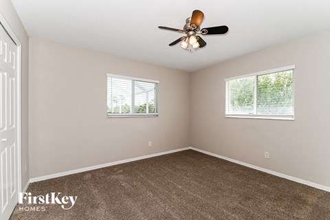 the master bedroom has a carpeted floor and a ceiling fan