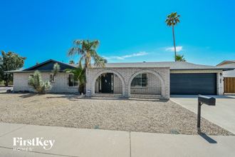 a white brick house with a garage and palm trees