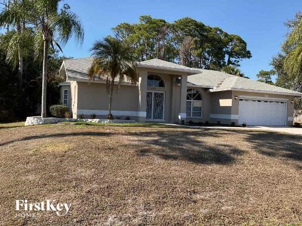 a white house with palm trees in front of it