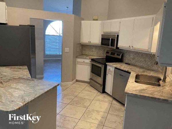 a kitchen with stainless steel appliances and marble counter tops