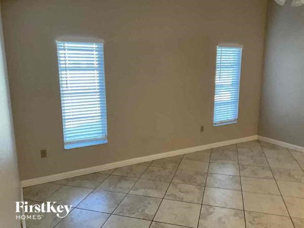 an empty room with two windows and a tiled floor