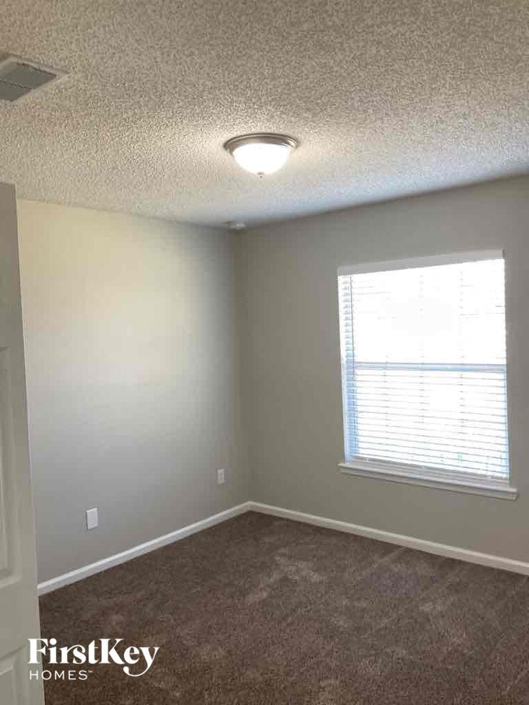 an empty room with a window and a lamp on the ceiling