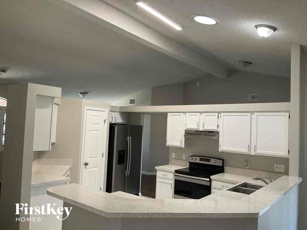 a kitchen with white cabinets and a stove and a refrigerator