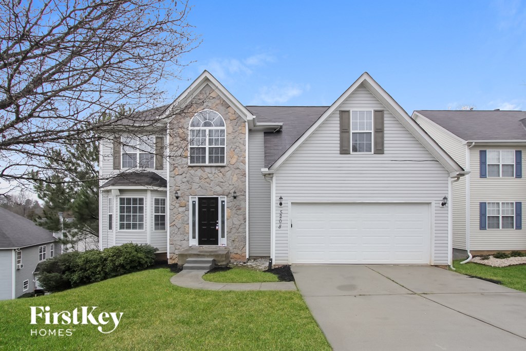 a white house with a stone facade and a white garage door