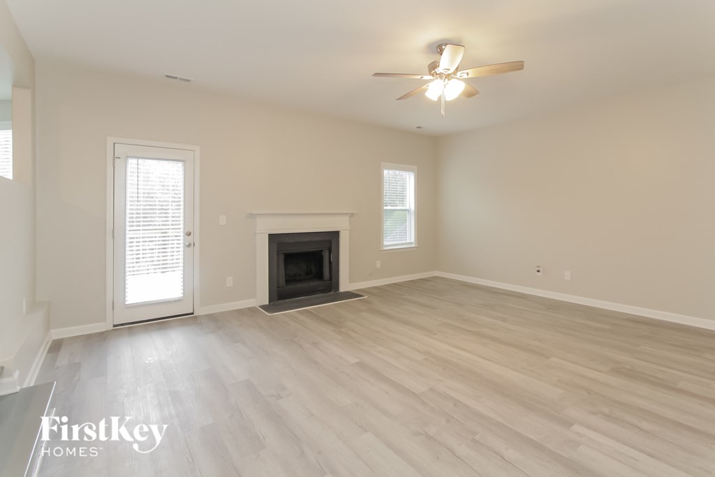 a living room with a fireplace and a ceiling fan
