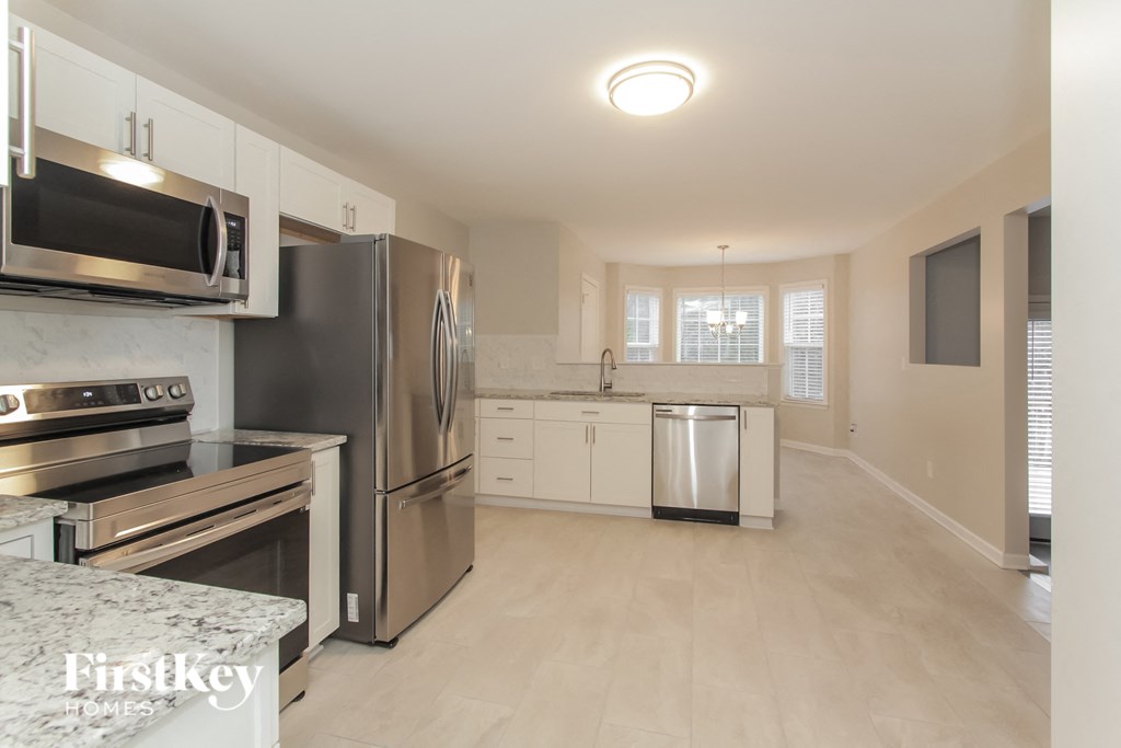 a large kitchen with stainless steel appliances and white cabinets