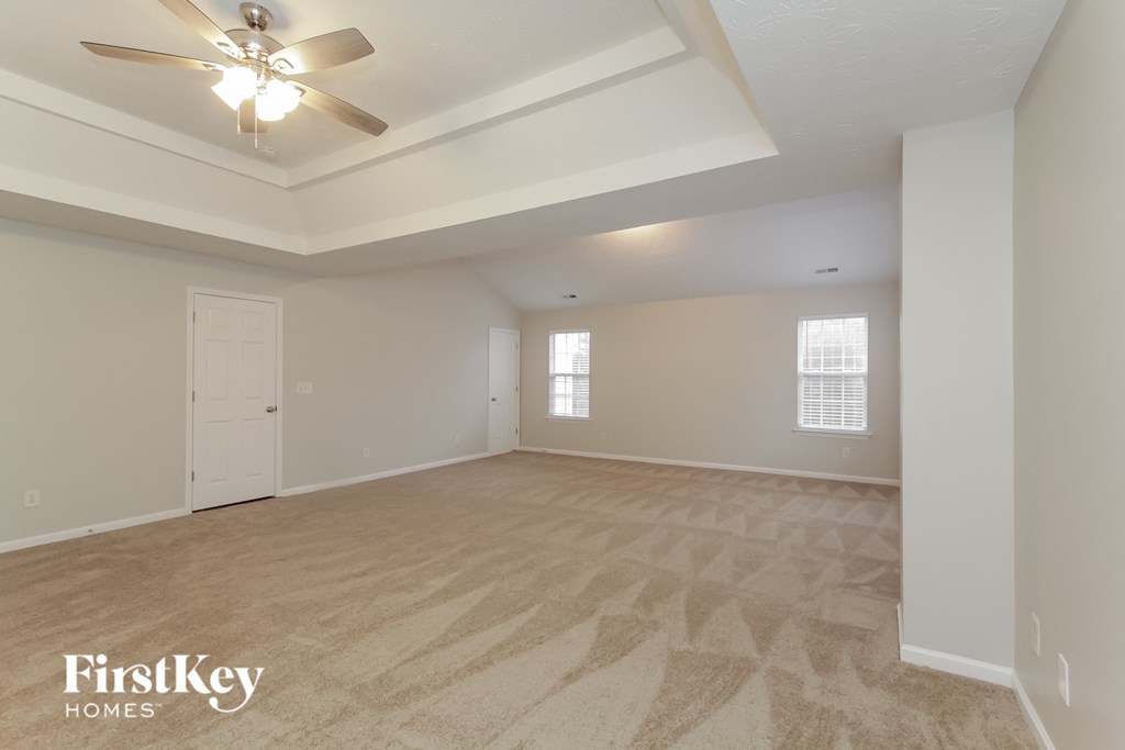 the living room of an empty house with a ceiling fan