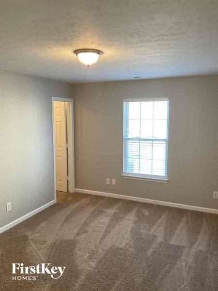 an empty living room with a window and a door