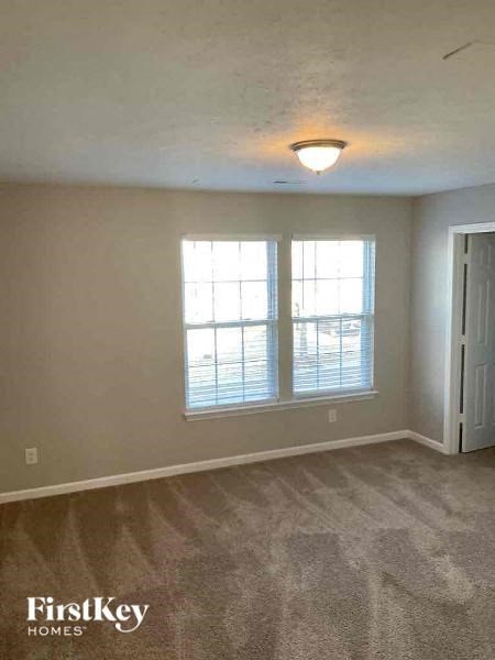 an empty living room with a window and a door