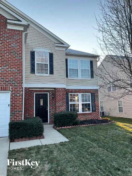 a brick house with a sidewalk in front of it