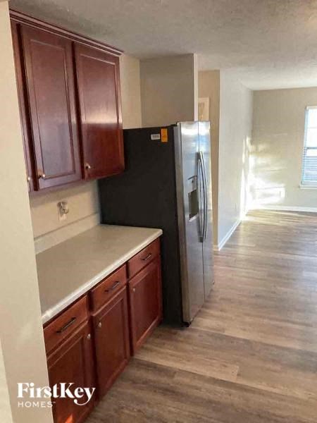 a kitchen with wooden floors and a black refrigerator
