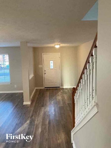 a hallway with a staircase and a white door