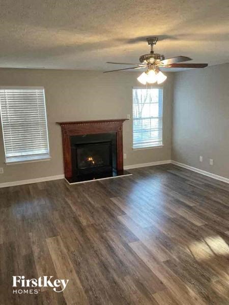 a living room with a fireplace and a ceiling fan