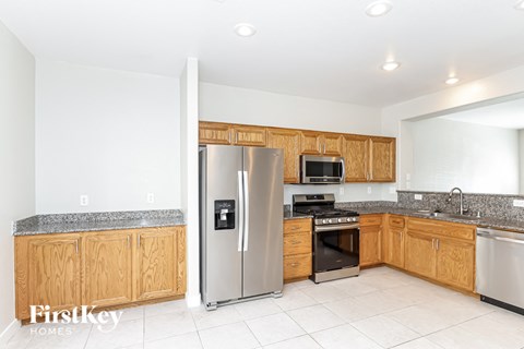 a kitchen with wooden cabinets and a stainless steel refrigerator