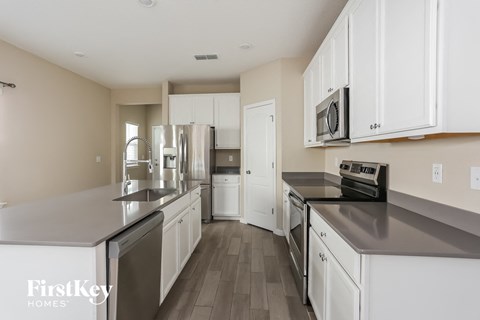 A kitchen with white cabinets and stainless steel appliances.
