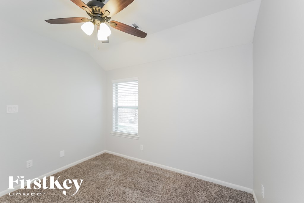 A room with a ceiling fan and a window.