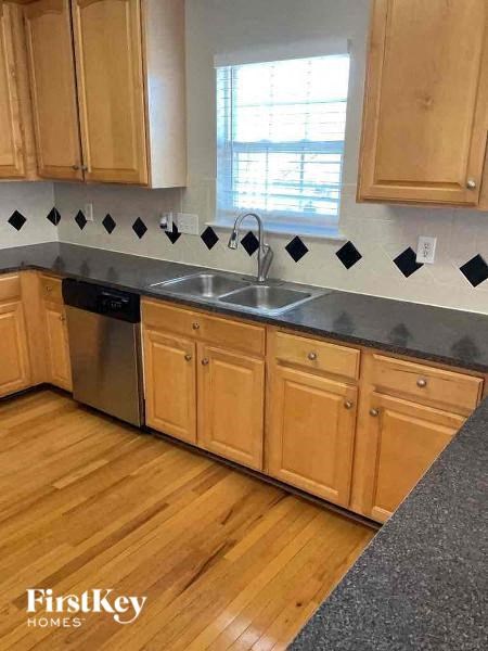 A kitchen with wooden cabinets and a black countertop.