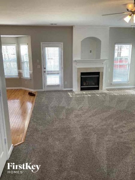 A living room with a fireplace and a fan on the ceiling.
