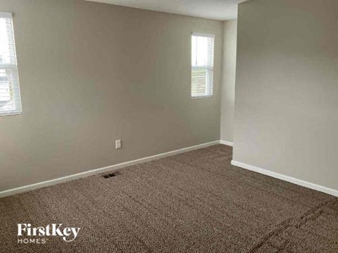 an empty room with a carpeted floor and a window