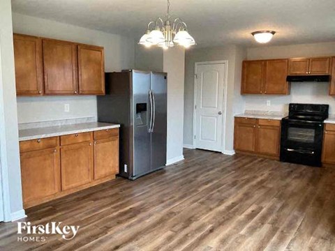 a kitchen with wooden cabinets and a stainless steel refrigerator