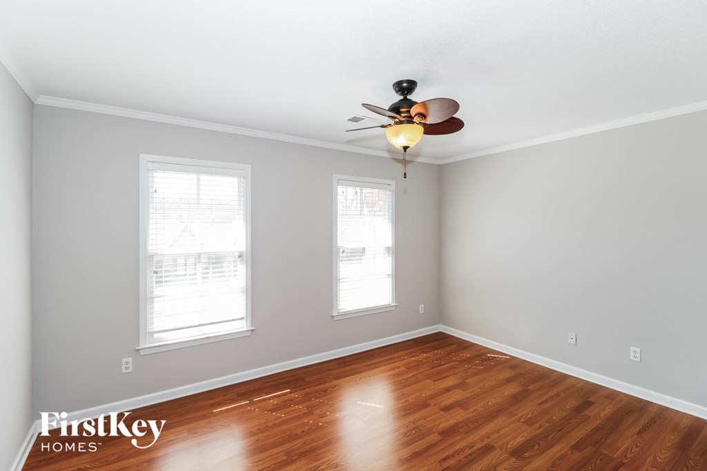 a living room with wood floors and a ceiling fan