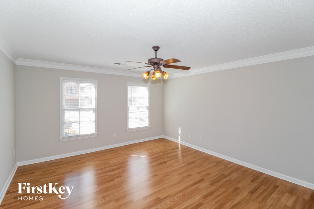 the living room of an empty house with a ceiling fan