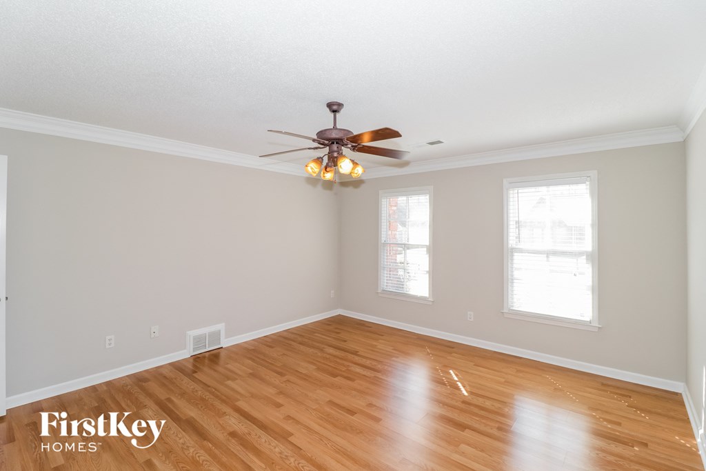the living room with wood floors and a ceiling fan
