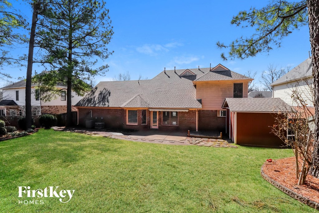 a brick house with a yard and a driveway