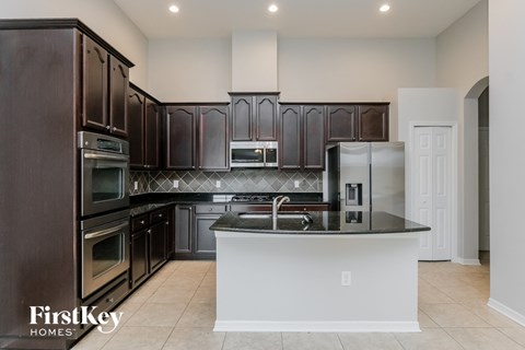 a kitchen with dark wood cabinets and a white counter top