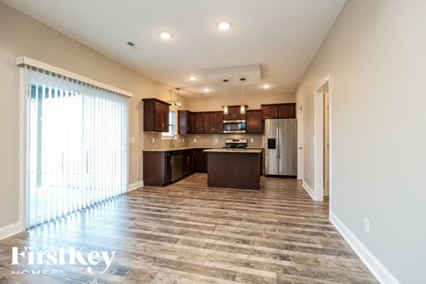 A spacious kitchen with wooden flooring and a large island.