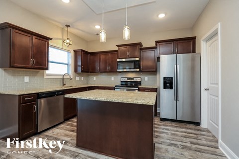 A kitchen with brown cabinets and a granite countertop.