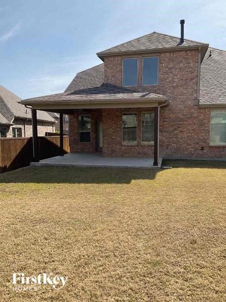 a brick house with a porch and a yard