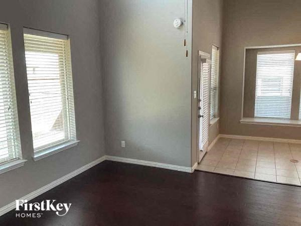 a living room with a hard wood floor and three windows