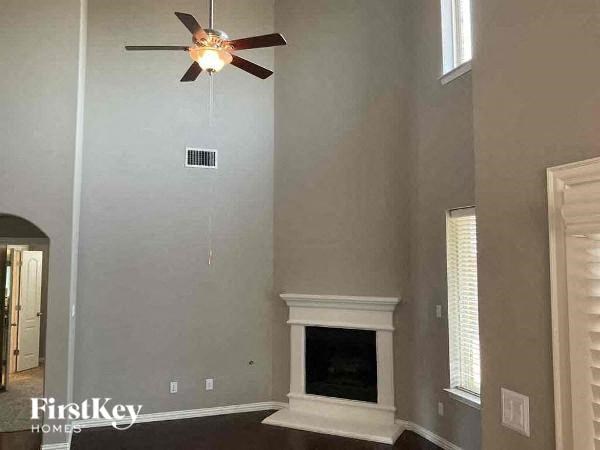 a living room with a ceiling fan and a fireplace