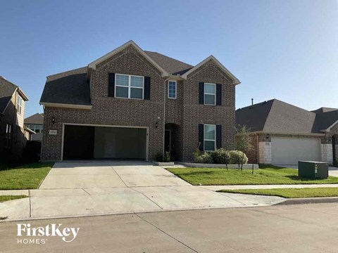 A brick house with a garage is for sale.
