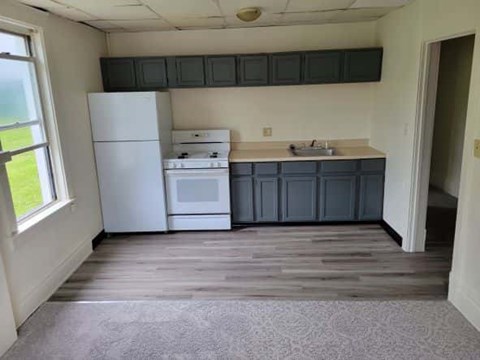 A kitchen with white appliances and a window.