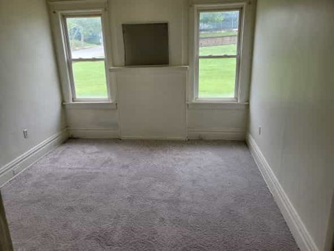 A room with a carpet floor and a window.