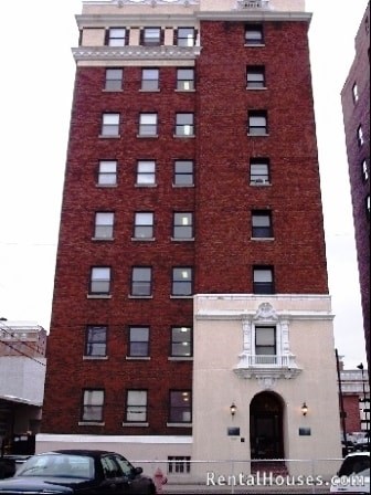A red brick building with a balcony on the second floor.
