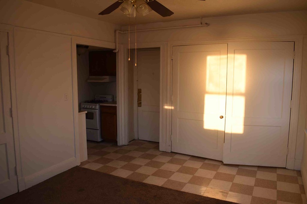 the living room with doors to the kitchen and a checkered floor