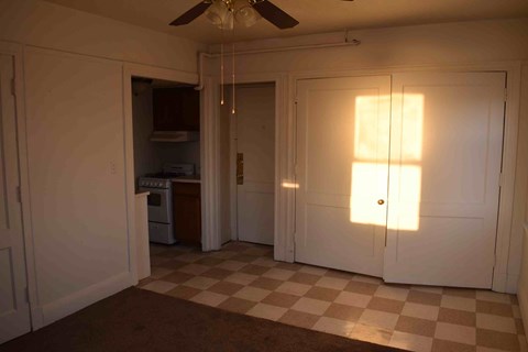 the living room with doors to the kitchen and a checkered floor